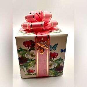 Beautiful music box designed to look like a wrapped gift with a pink bow on top.